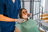 Woman examining her teeth at the dentist