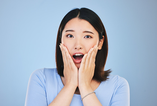 Asian, portrait and woman with surprise from announcement, news or horror story on blue background in studio. Shock, face and person with wow deal, discount or emoji for crazy promotion and offer