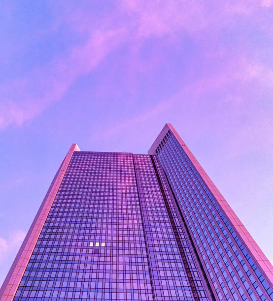 modern office building in the sky at sunset with three windows turn on the light and the pink sky