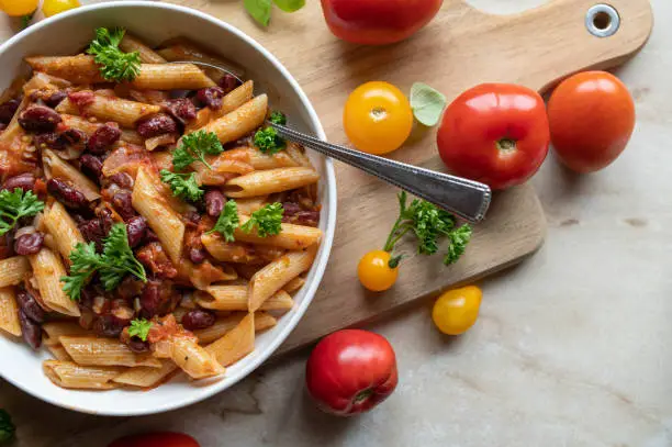 Delicious vegan or vegetarian pasta dish with kidney beans, penne and homemade tomato sauce from fresh garden tomatoes. Zero waste food