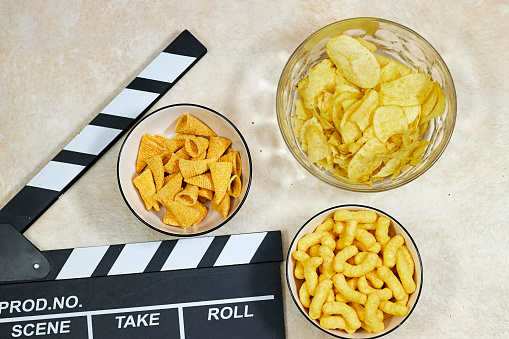 clapper board of video cinema in studio and bowls of different chips  on grunge background