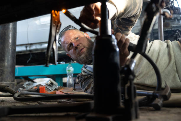 le mécanicien automobile professionnel utilise une machine à souder pour réparer une voiture. - car bodywork flash photos et images de collection