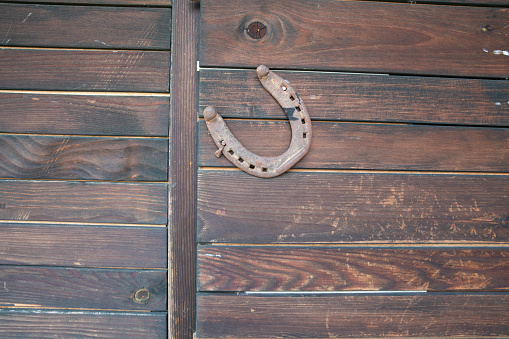 Horseshoe on a wooden old door, a symbol of good luck and wealth