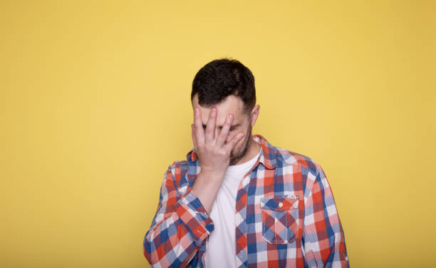istock Man face palm and mistake in studio with thinking, regret and anxiety for fail on yellow. 1688739621