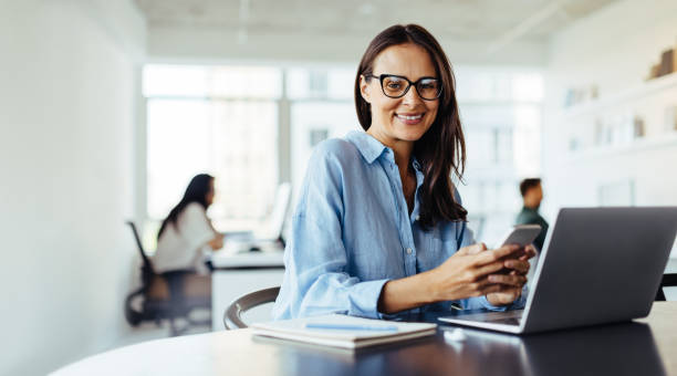 istock Mature business woman using a mobile phone in an office 1688743065
