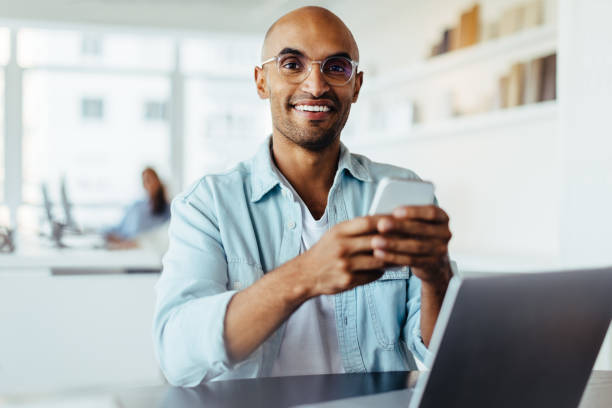 istock Business man using a smartphone while sitting with a laptop 1688744315