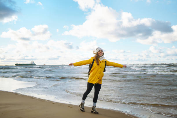 istock A female traveler in a yellow coat and backpack walks. 1688753407