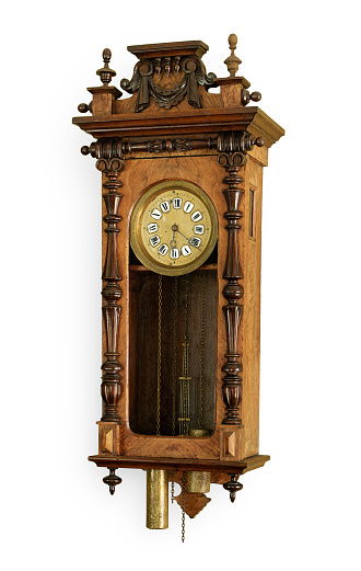 An old-fashioned wooden wall clock on a wood wall.