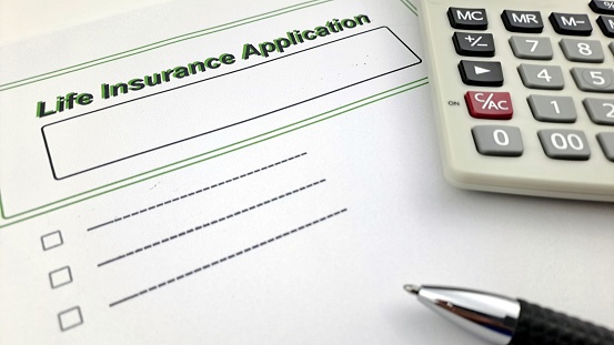 Insurance documents. Insurance documents on a desk with calculator, pen and notepad.