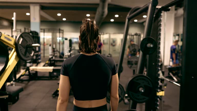 Determined Strong Woman Walks Through the Gym, Ready to Train