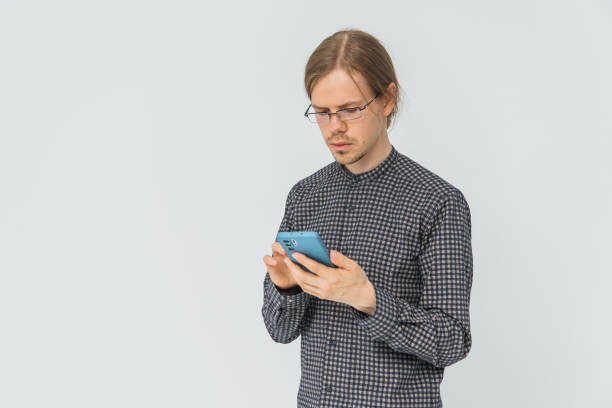 istock Young man with mobile phone in hand in studio. Portrait. Businessman 1688770090