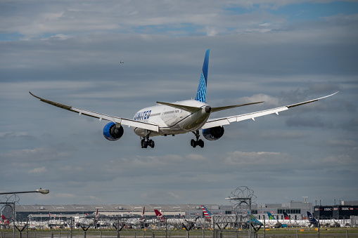 Rear view of a United Airlines Boeing 787-9 Dreamliner landing at London Heathrow Airport, airport buildings in the background.