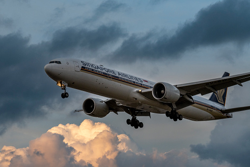 A Singapore Airlines Boeing 777 prepares to land at London Heathrow Airport at dusk.