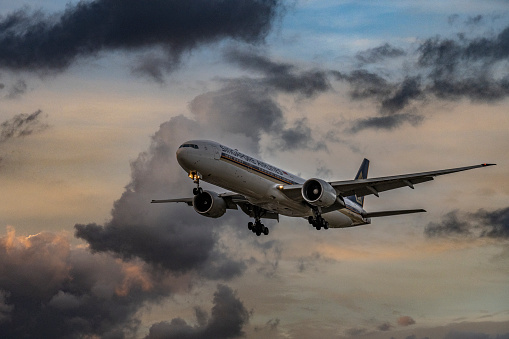 A Singapore Airlines Boeing 777-312(ER) approaches to land at London Heathrow Airport at dusk.