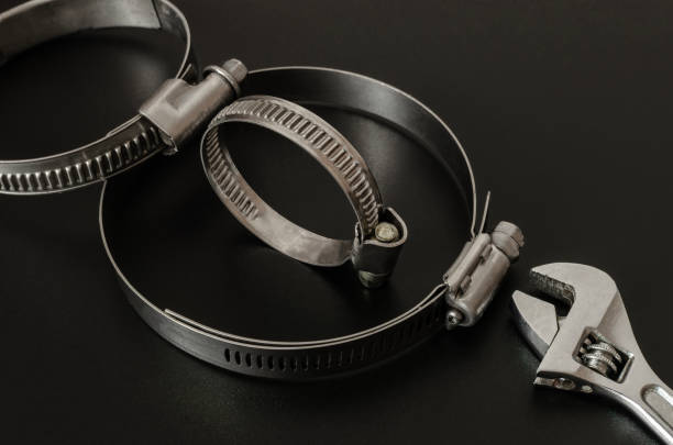 Clamps for fastening rubber pipes and an adjustable wrench on a black background