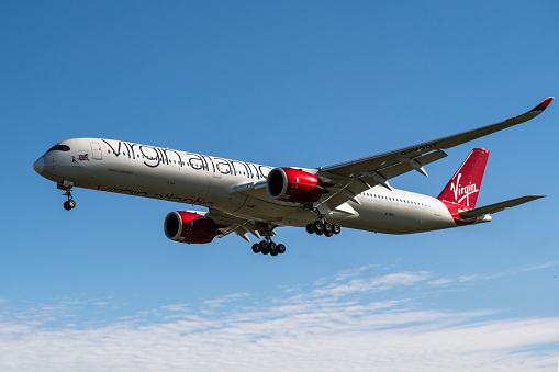 A Virgin Atlantic Airbus A350 approaches to land at London Heathrow Airport on a beautiful sunny day.