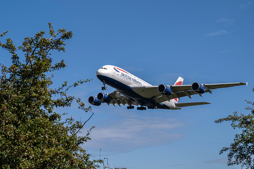 A view of a low-flying British Airways Airbus A380-841 on approach to London Heathrow Airport on a beautiful sunny day.