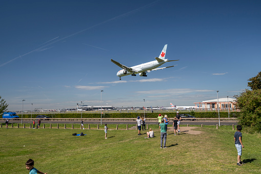 Spectators in the green area at Myrtle Avenue, located near the eastern end of the southern runway of Heathrow Airport, 27L, admire planes landing at the airport. It's the most popular place to watch planes in London.