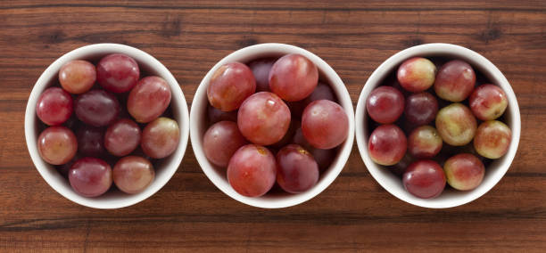 Red grapes Three bowls containing different types of red grapes healthy eating red above studio shot stock pictures, royalty-free photos & images