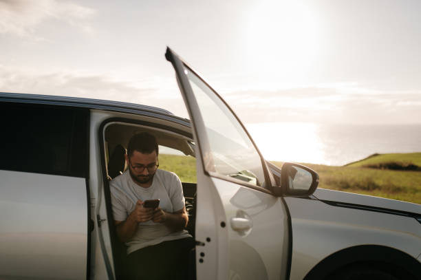 istock Man with smart phone at car 1688854715