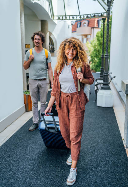 istock Couple with suitcases entering in the hotel 1688857483