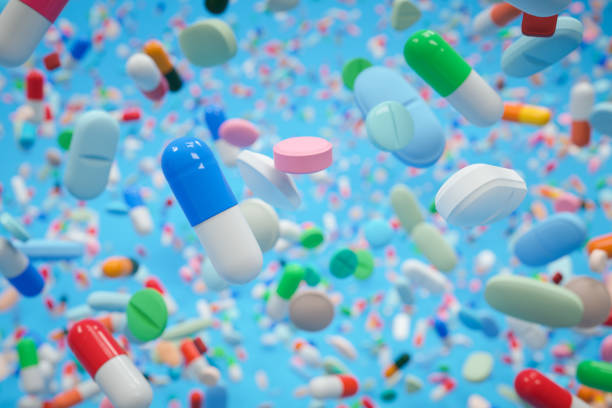 bunte pillen auf blauem hintergrund - painkiller pill capsule birth control pill stock-fotos und bilder