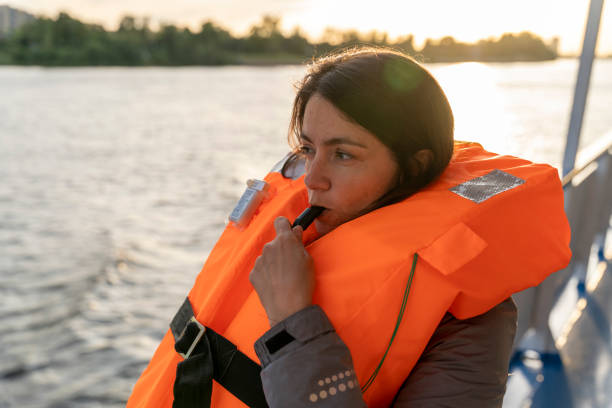 istock woman wearing an orange life jacket blows a whistle 1688907511