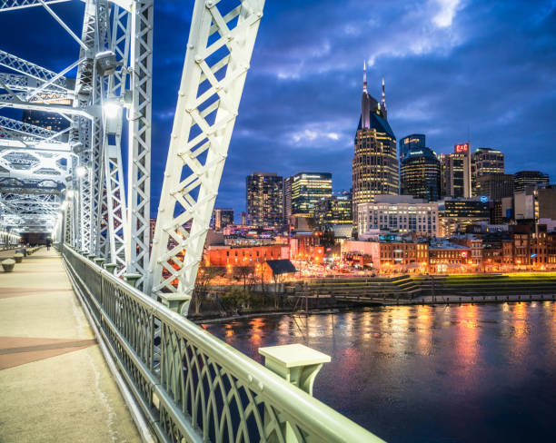 Nashville at dusk A view of downtown Nashville's skyline at dusk, from the Shelby Street Bridge over the Cumberland River. nashville tennessee bridge stock pictures, royalty-free photos & images