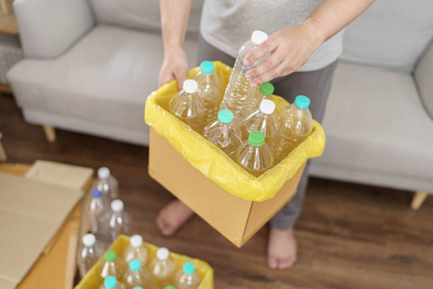 istock Home recycle eco green zero concept Man throwing empty plastic bottle in recycling bin with yellow garbage bags at home 1688950574