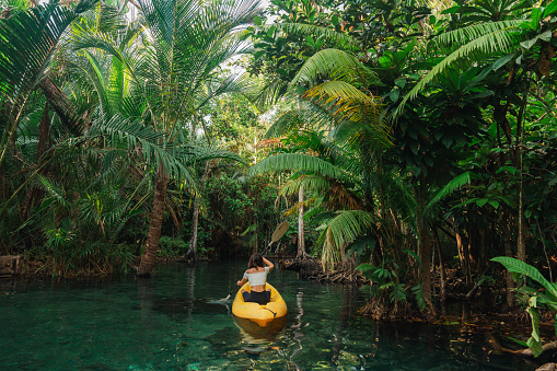 Young woman on yellow kayak  in the  lagoon in jungles