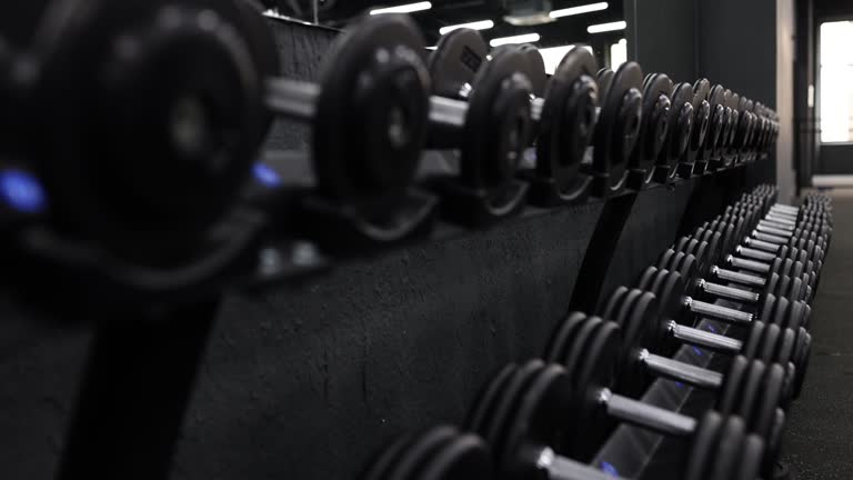 Closeup of row of black dumbbells in gym