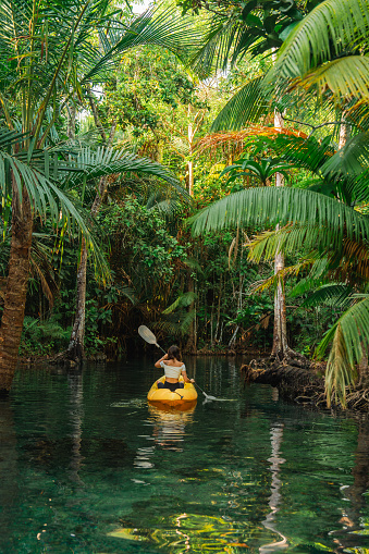 Young woman on yellow kayak  in the  lagoon in jungles