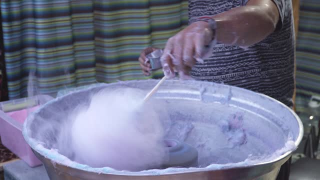 Man making cotton candy in a street market
