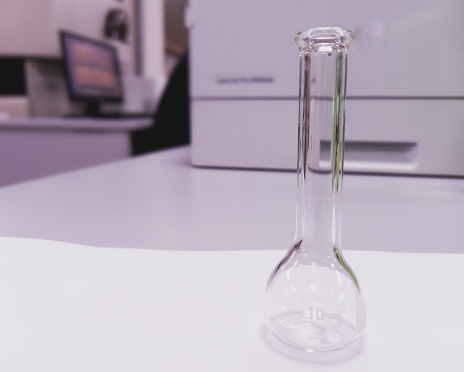 Volumetric flask used to prepare the desired concentration of the substance in the laboratory. White laboratory background.