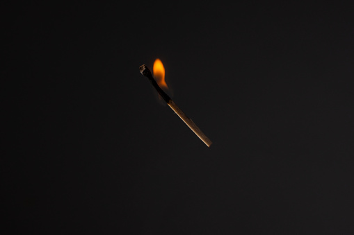 Fire and smoke. Burning and smoking match on a black background. Heat and light from fire flame