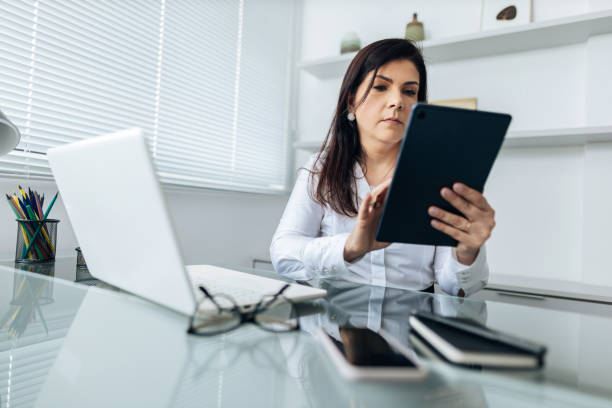 istock Businesswoman using tablet and laptop in office 1689016076