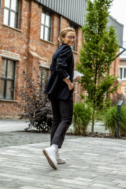 istock Young business woman in black looking contented 1689052390