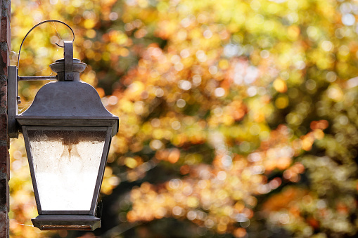 A weathered copper porch light on a bright fall day