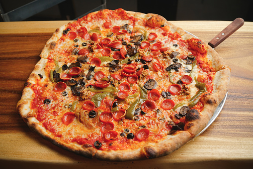 Supreme pizza with pepperoni, olives, peppers and onions