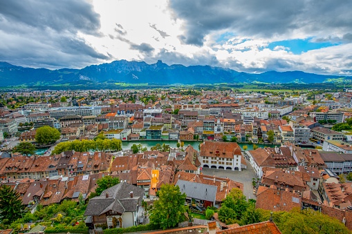Historical Thun city and lake Thun with snow covered Bernese Highlands swiss Alps mountains in background.