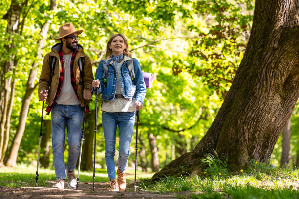 istock Young couple with scandinavian sticks walking and talking 1689065532