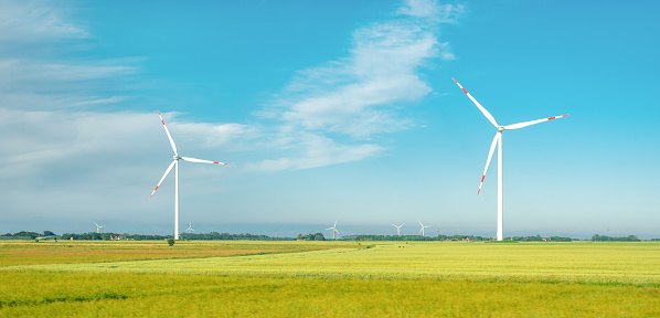 Aerial view of a wind turbine in Flevoland standing in between   fields growing crops in spring The Netherlands.