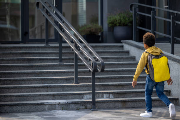 istock African american schoolboy with a backpack on the stairs 1689066758