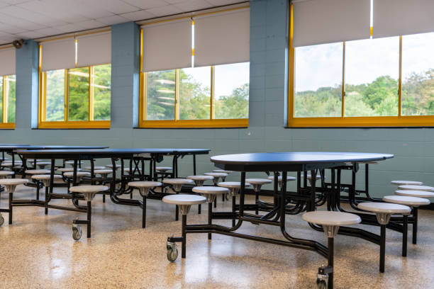 istock Blue folding table with attached seats in a school cafeteria. 1689073539