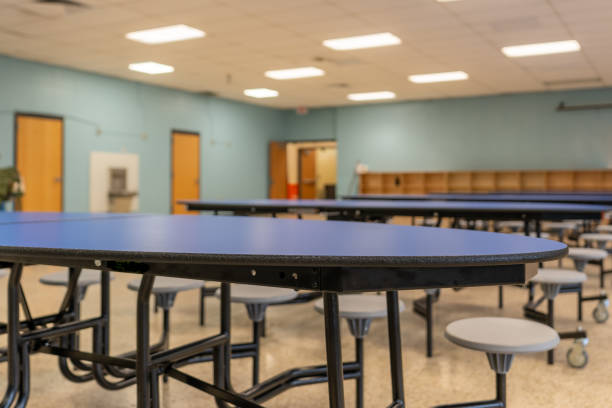 istock Blue folding table with attached seats in a school cafeteria. 1689073546
