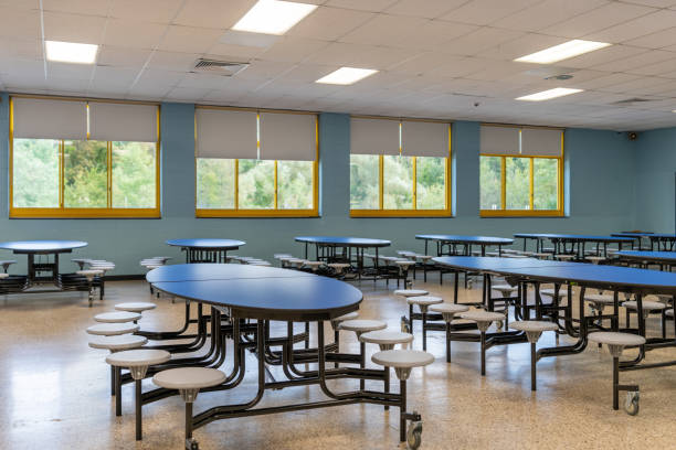 istock Blue folding table with attached seats in a school cafeteria. 1689074599