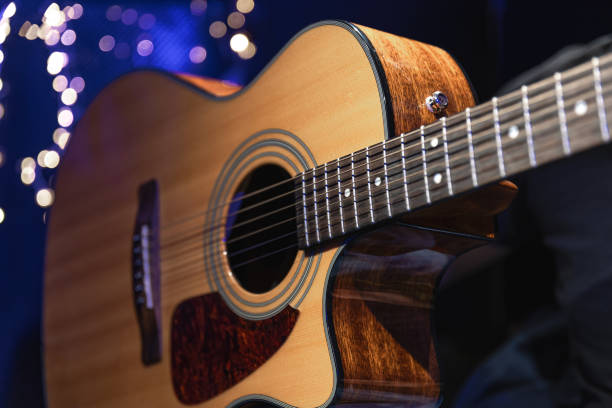 istock Close-up, acoustic guitar on a dark background with bokeh lights. 1689088116