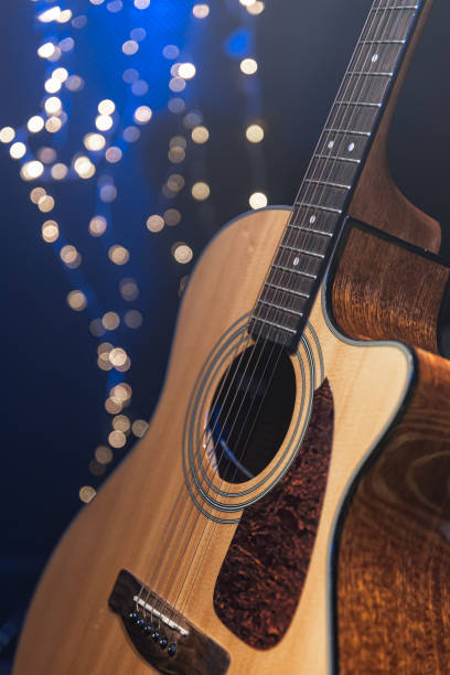 istock Close-up, acoustic guitar on a dark background with bokeh lights. 1689088192