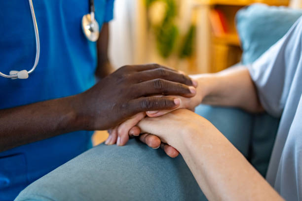 istock Nurse holding an elderly woman’s hands in a retirement home 1689094637