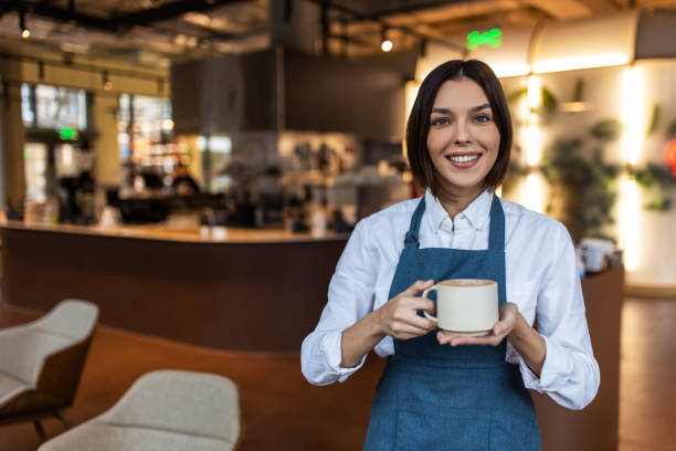istock Young woman holding a cup with cappuccino in hands 1689103057